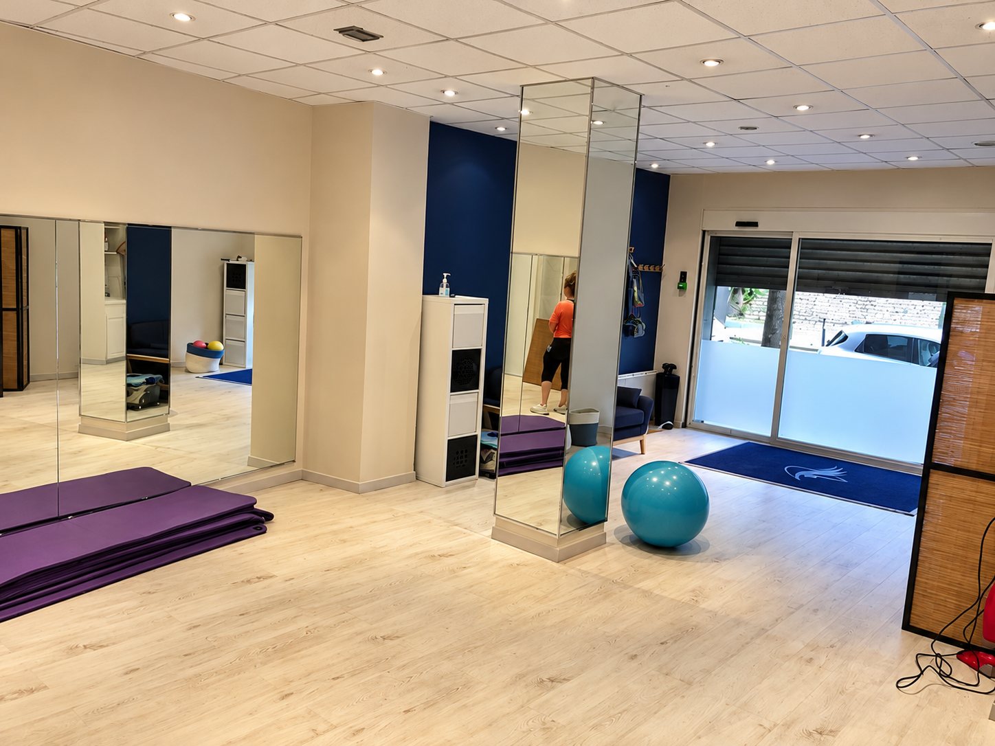 Salle de cours avec miroirs, tapis violets et ballons bleus